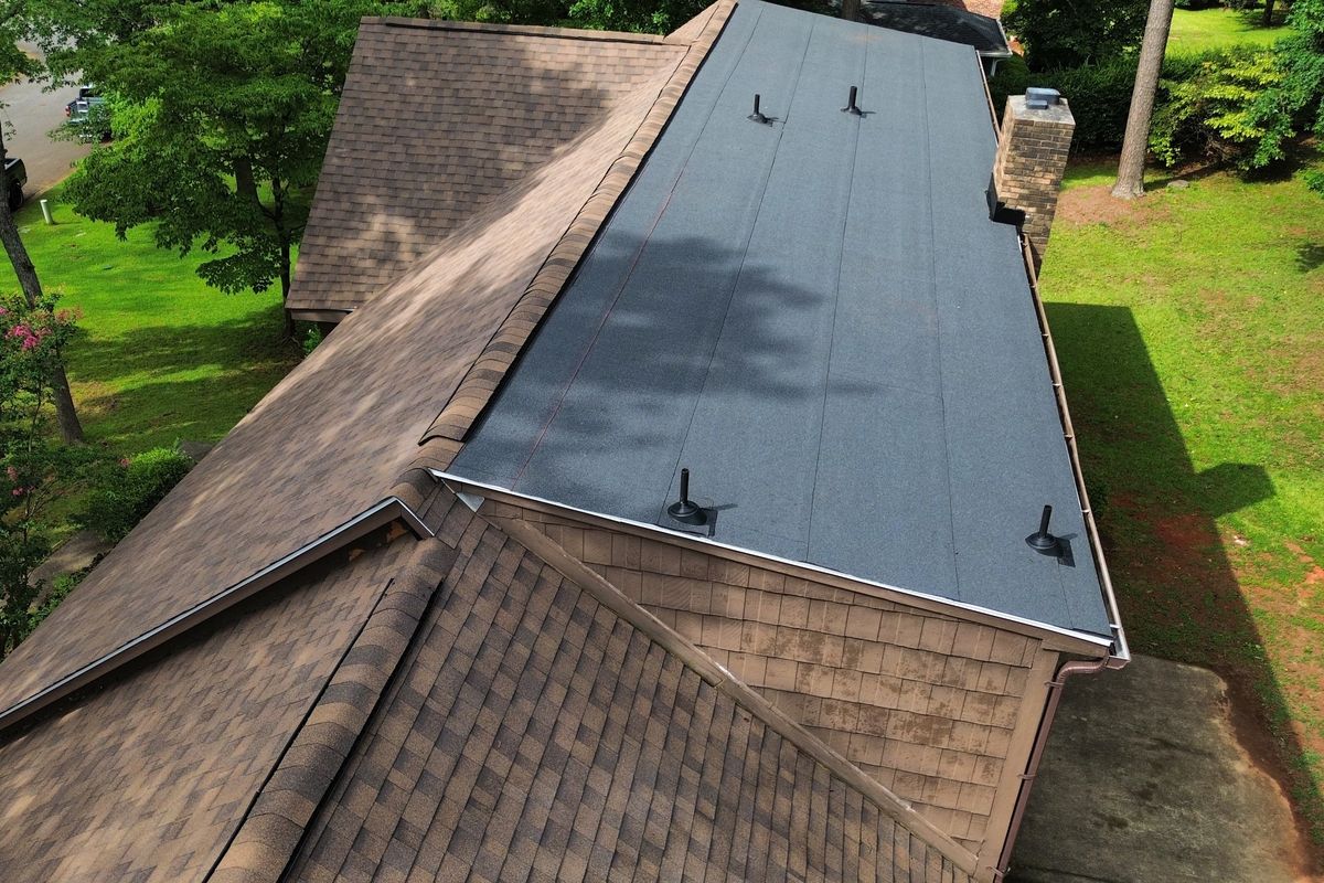 Drone view of a finished dark gray shingle roof with clean ridge lines.
